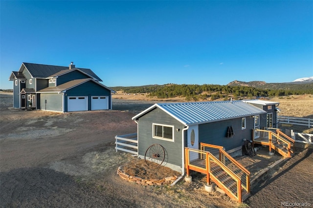 10617 County Rd 1, Florissant, CO 80816 - view of front of home with metal roof, a garage, a mountain view, and dirt driveway
