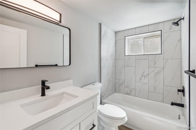 full bathroom with toilet, vanity, and tiled shower / bath