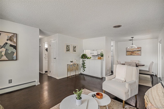 64 Nome Way Unit A, Aurora, CO 80012 - living area featuring baseboard heating, dark wood-type flooring, and a textured ceiling