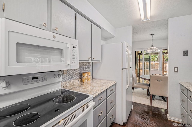 64 Nome Way Unit A, Aurora, CO 80012 - kitchen featuring white appliances, gray cabinetry, a textured ceiling, dark wood-style flooring, and decorative backsplash