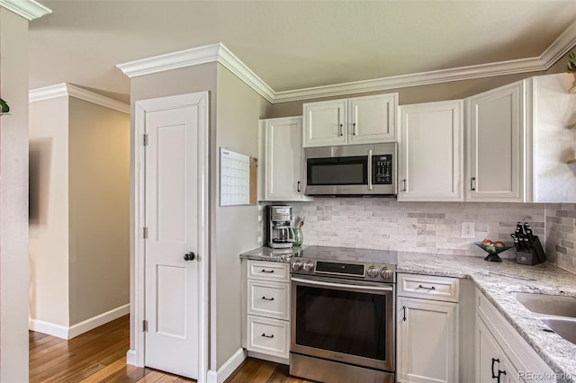 9146 W 89th Ct, Broomfield, CO 80021 - kitchen featuring appliances with stainless steel finishes, light wood-type flooring, backsplash, light stone counters, and ornamental molding
