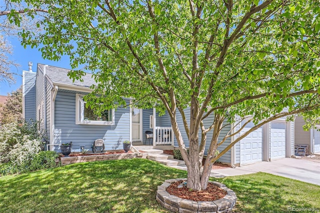 obstructed view of property with driveway, a chimney, a front yard, and a garage