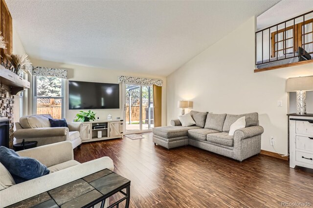 living area with a textured ceiling, wood finished floors, and lofted ceiling