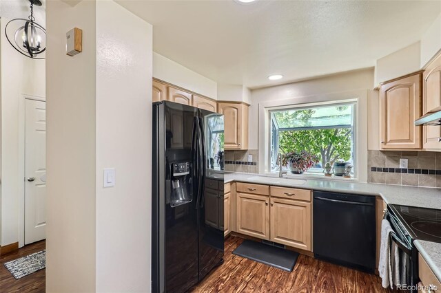 kitchen with dark wood-style flooring, light brown cabinets, light countertops, backsplash, and black appliances