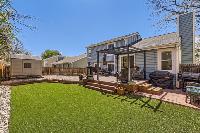 back of house with a chimney, a storage shed, a deck, a fenced backyard, and a pergola