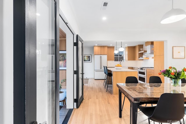 dining area with light wood-style floors, recessed lighting, and visible vents