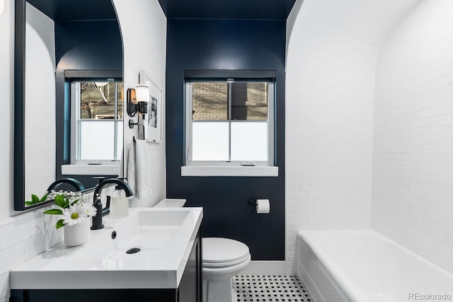 full bathroom featuring toilet, tile patterned floors, baseboards, and vanity