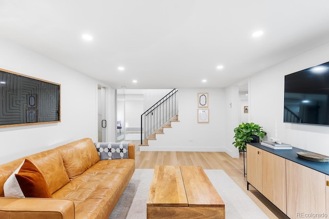 living area featuring baseboards, light wood finished floors, stairway, and recessed lighting