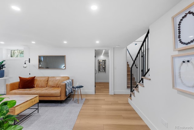 living room with light wood-style flooring, stairs, baseboards, and recessed lighting