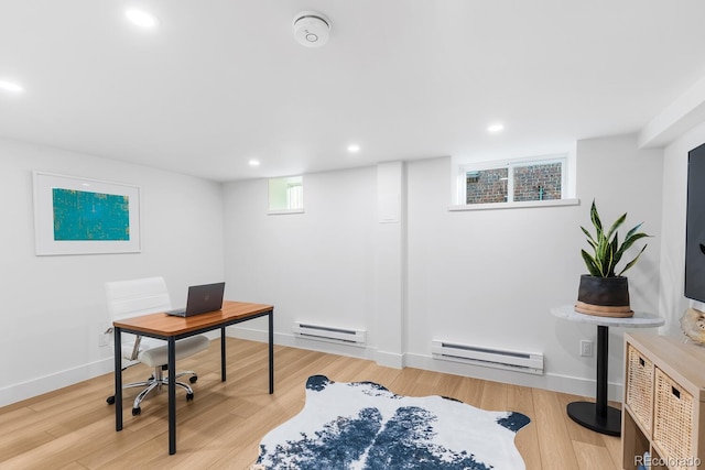 office space with a baseboard heating unit, recessed lighting, light wood-style flooring, and baseboards