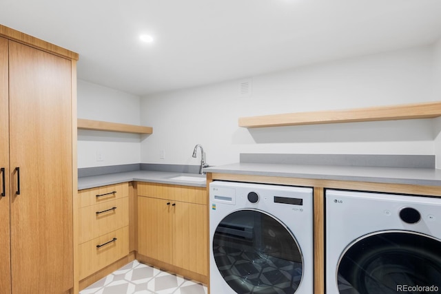 washroom featuring cabinet space, visible vents, washer and clothes dryer, light floors, and a sink