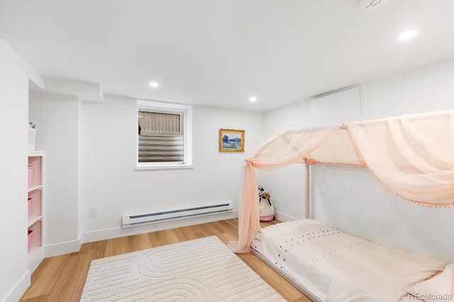 bedroom with baseboards, baseboard heating, wood finished floors, and recessed lighting