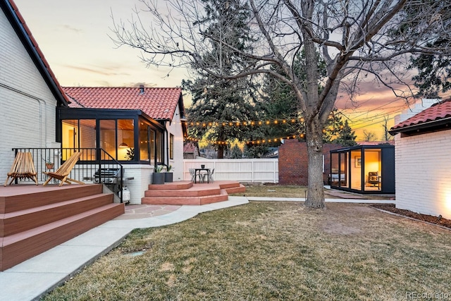 yard at dusk with fence and a patio