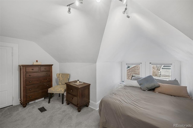 bedroom featuring light carpet, track lighting, and lofted ceiling