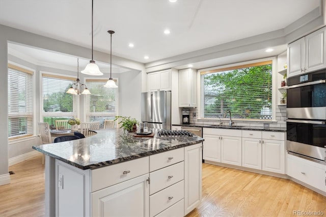 4059 Nevis St, Boulder, CO 80301 - kitchen with stainless steel appliances, a sink, light wood finished floors, backsplash, and white cabinetry