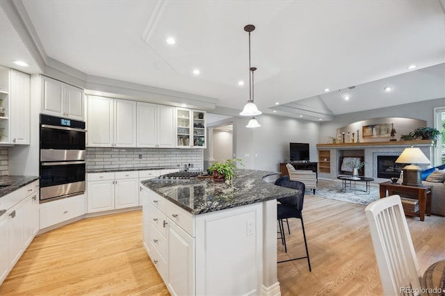 4059 Nevis St, Boulder, CO 80301 - kitchen with stainless steel appliances, a kitchen island, light wood-style flooring, decorative backsplash, and vaulted ceiling