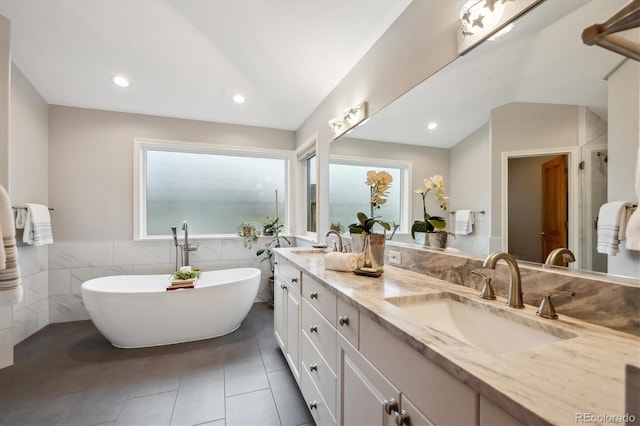 4059 Nevis St, Boulder, CO 80301 - bathroom with double vanity, a freestanding tub, tile patterned floors, tile walls, and lofted ceiling