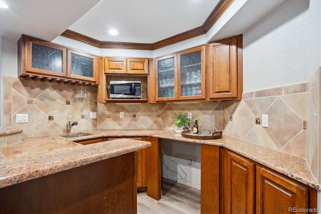 4059 Nevis St, Boulder, CO 80301 - kitchen with stainless steel microwave, a sink, crown molding, light stone countertops, and brown cabinets