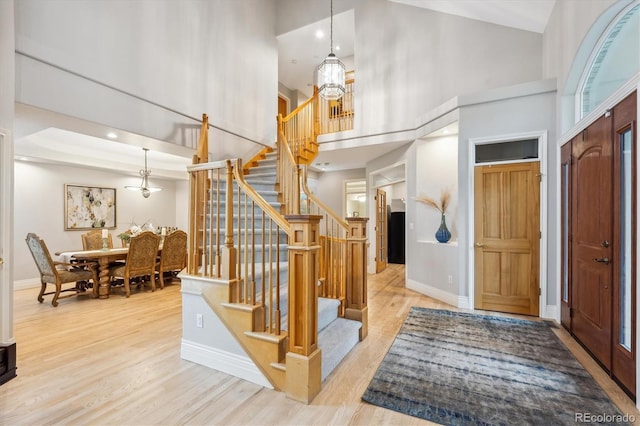 4059 Nevis St, Boulder, CO 80301 - entryway with a towering ceiling, wood finished floors, stairs, a chandelier, and baseboards