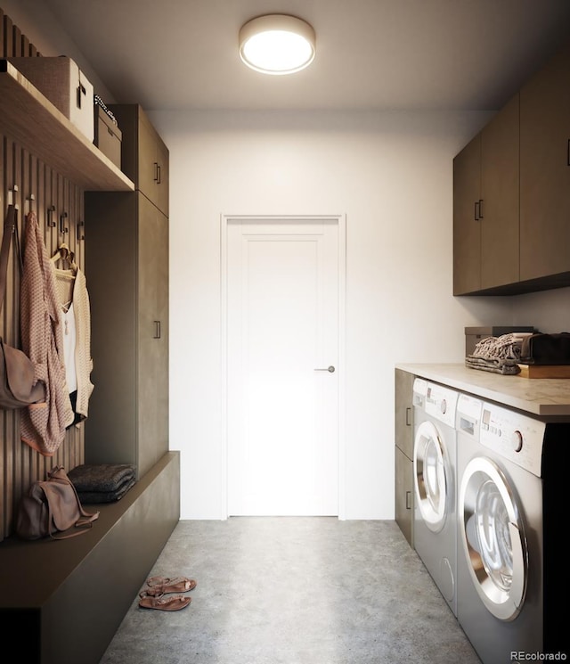 clothes washing area featuring washer and dryer and cabinets