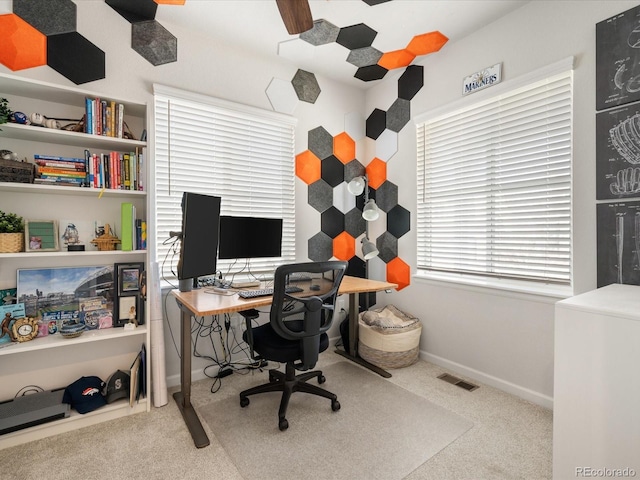 office space featuring light carpet, baseboards, and visible vents