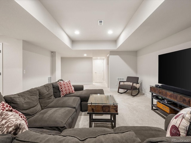 living area with recessed lighting, a tray ceiling, light colored carpet, and baseboards