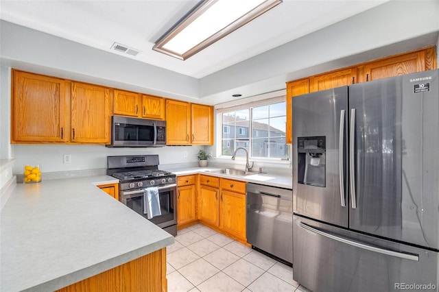 8199 Welby Rd Unit 4106, Denver, CO 80229 - kitchen featuring stainless steel appliances, light countertops, brown cabinetry, and light tile patterned flooring