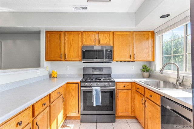 8199 Welby Rd Unit 4106, Denver, CO 80229 - kitchen with stainless steel appliances, light countertops, light tile patterned floors, and brown cabinets