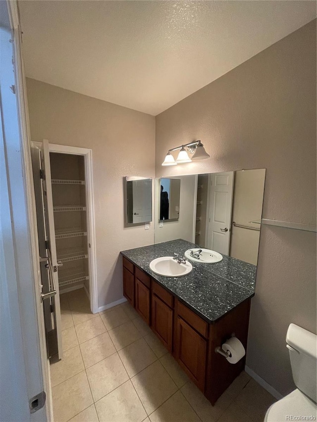 bathroom with vanity, toilet, and tile patterned flooring