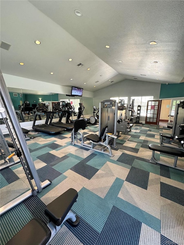 gym featuring a textured ceiling and lofted ceiling