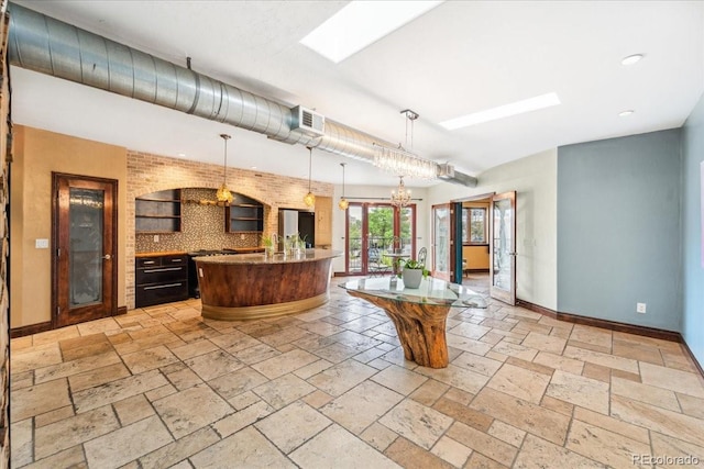 2150 Curtis St, Denver, CO 80205 - kitchen featuring baseboards, decorative backsplash, stone tile flooring, pendant lighting, and recessed lighting
