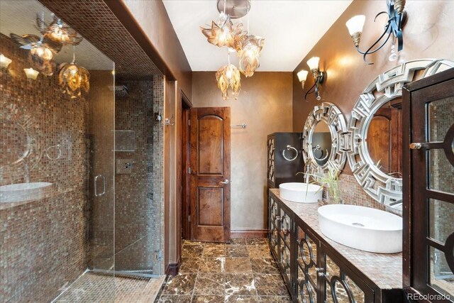 2150 Curtis St, Denver, CO 80205 - bathroom featuring a shower stall, baseboards, double vanity, and stone finish flooring