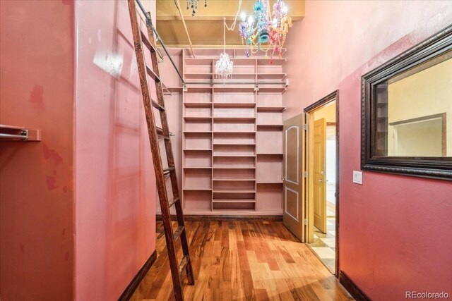 2150 Curtis St, Denver, CO 80205 - corridor featuring wood finished floors, a chandelier, a towering ceiling, and baseboards