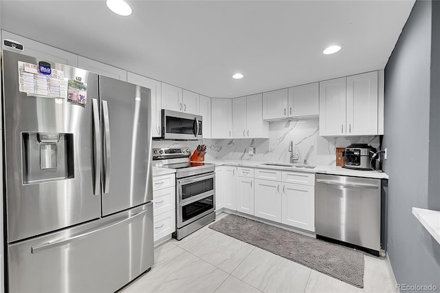 14300 E Marina Dr Unit 109, Aurora, CO 80014 - kitchen with stainless steel appliances, a sink, white cabinets, recessed lighting, and decorative backsplash