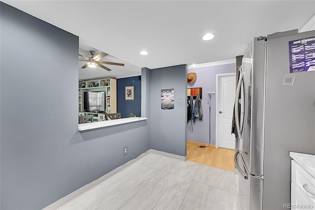 14300 E Marina Dr Unit 109, Aurora, CO 80014 - kitchen featuring freestanding refrigerator, ceiling fan, ornamental molding, white cabinets, and baseboards
