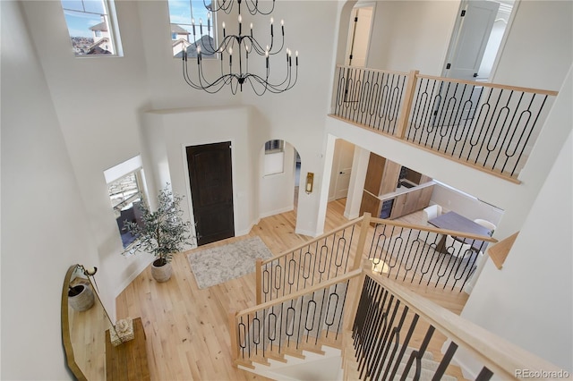 foyer with an inviting chandelier, hardwood / wood-style floors, and a high ceiling