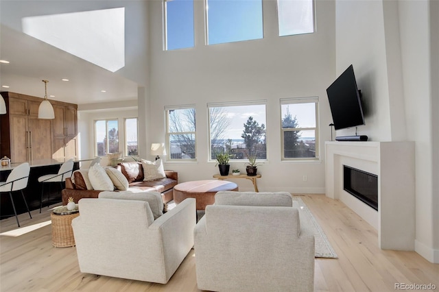 living room with a towering ceiling and light hardwood / wood-style floors