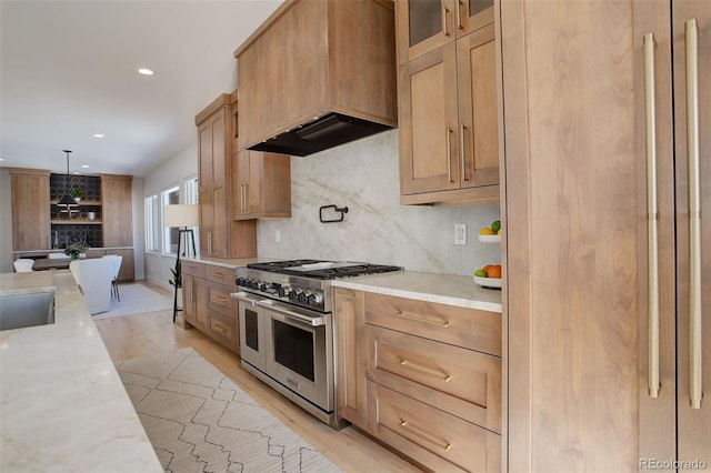 kitchen featuring light hardwood / wood-style flooring, double oven range, custom range hood, pendant lighting, and backsplash