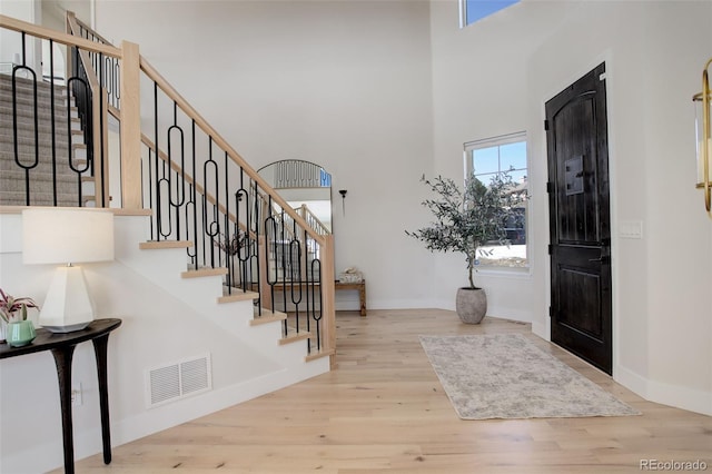 foyer featuring a towering ceiling and light hardwood / wood-style floors