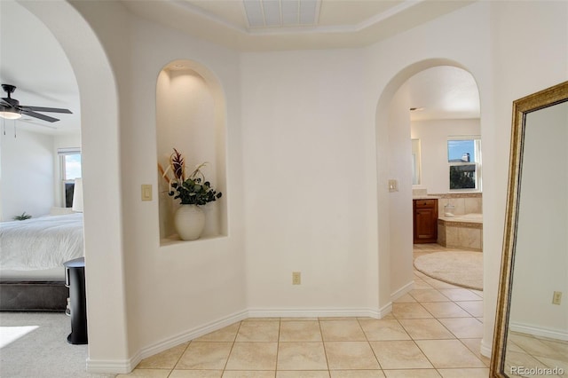 hallway with light tile patterned floors and a healthy amount of sunlight