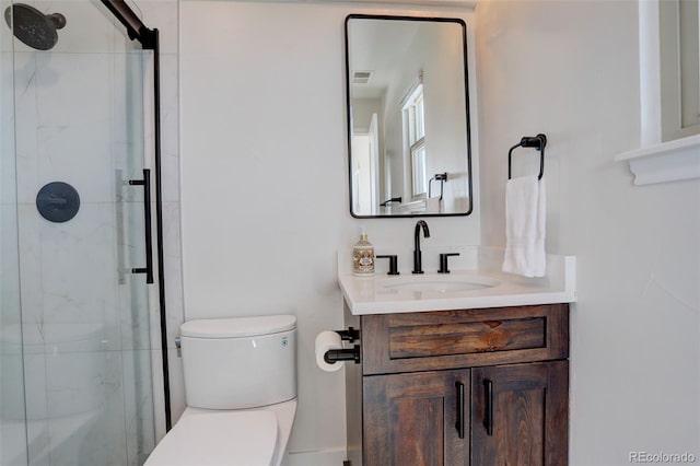 bathroom featuring vanity, an enclosed shower, and toilet