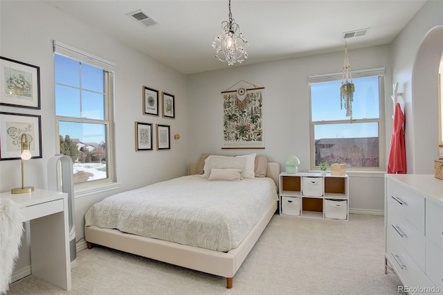 carpeted bedroom with multiple windows and a chandelier