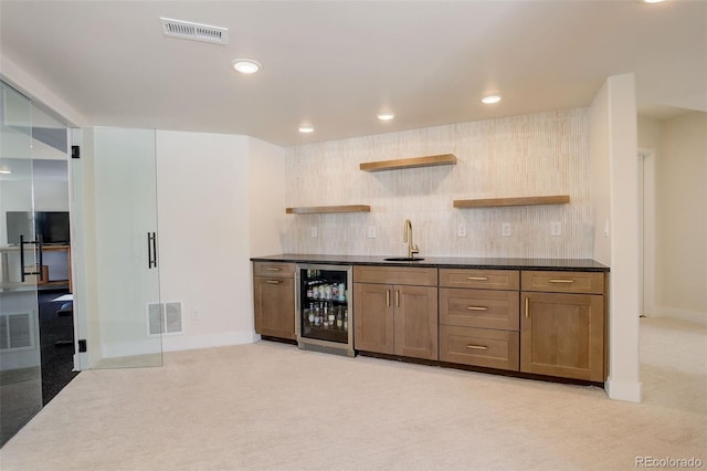 kitchen with tasteful backsplash, light colored carpet, beverage cooler, and sink