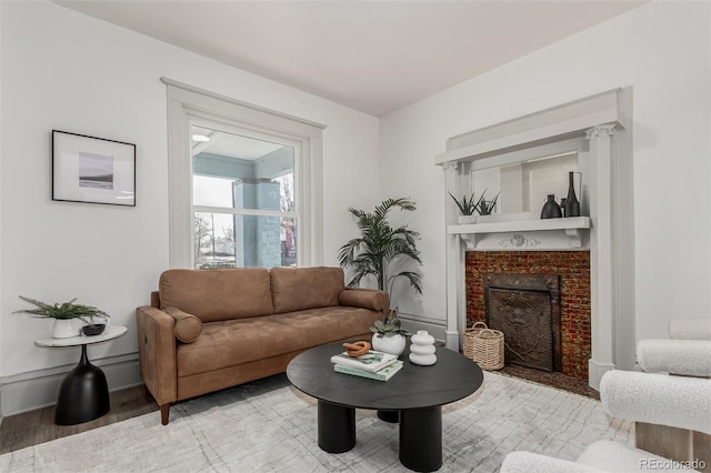 living room featuring light wood-style flooring, baseboards, and a fireplace with flush hearth