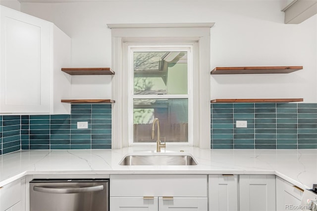 kitchen featuring white cabinets, dishwasher, light stone counters, open shelves, and a sink