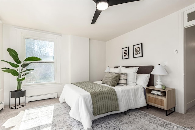 bedroom featuring a baseboard heating unit, ceiling fan, and carpet floors