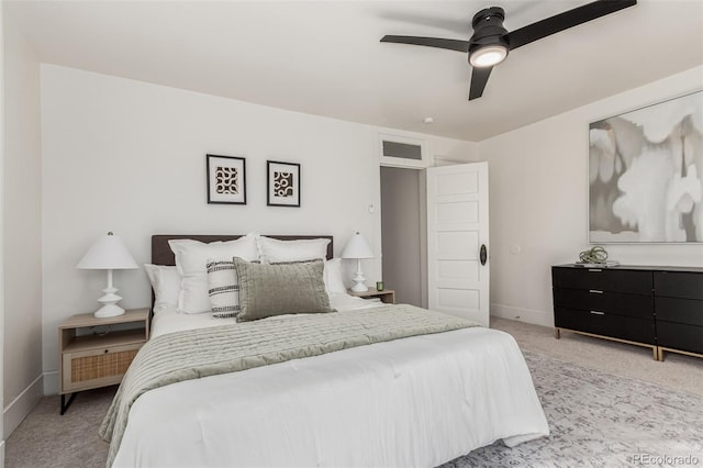 bedroom with light colored carpet, ceiling fan, and baseboards