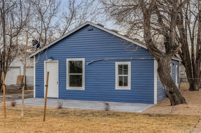 back of house featuring a lawn and a patio area