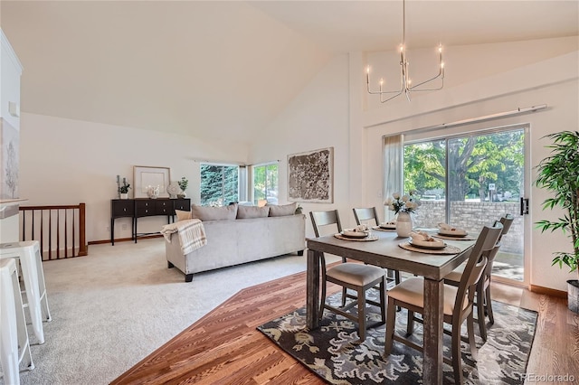 dining room with high vaulted ceiling, a chandelier, healthy amount of natural light, and baseboards