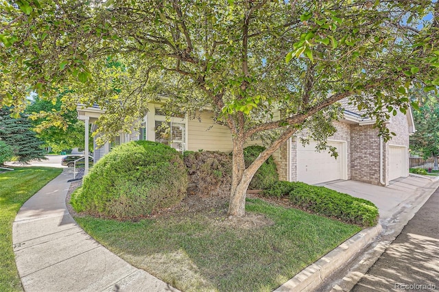 view of front of property with driveway, brick siding, and a garage